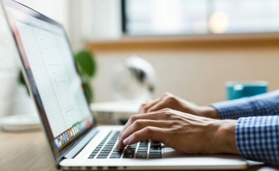 person typing on silver Macbook