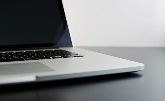 silver laptop computer on black table