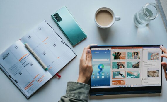 person using Windows 11 computer beside white ceramic mug on white table